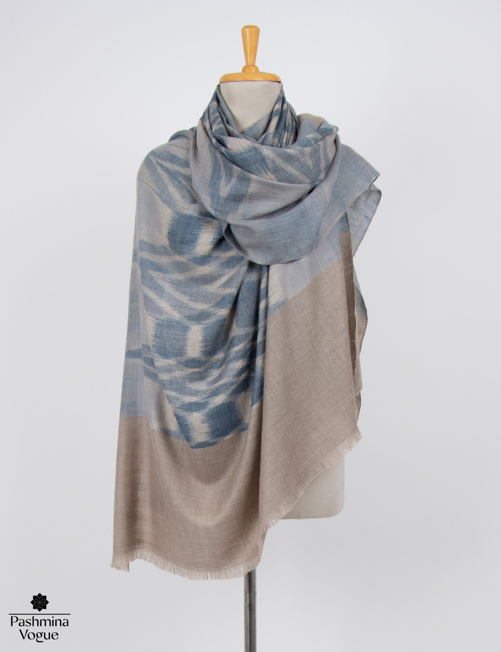 Authentic handwoven Ikat Pashmina shawl styled as a Kashmir luxury wrap featuring sharp geometric resist-dye patterns.